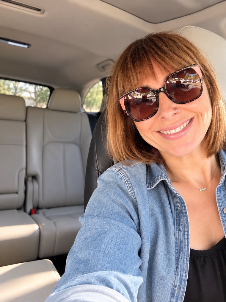 Kristina smiling in sunglasses and a denim jacket